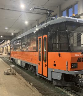 Arbeitswagen mit neuer orange-schwarzer Gestaltung in einer Werkhalle, beschriftet mit 'Schleifwagen' und 'MVB'