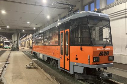 Arbeitswagen mit neuer orange-schwarzer Gestaltung in einer Werkhalle, beschriftet mit 'Schleifwagen' und 'MVB'