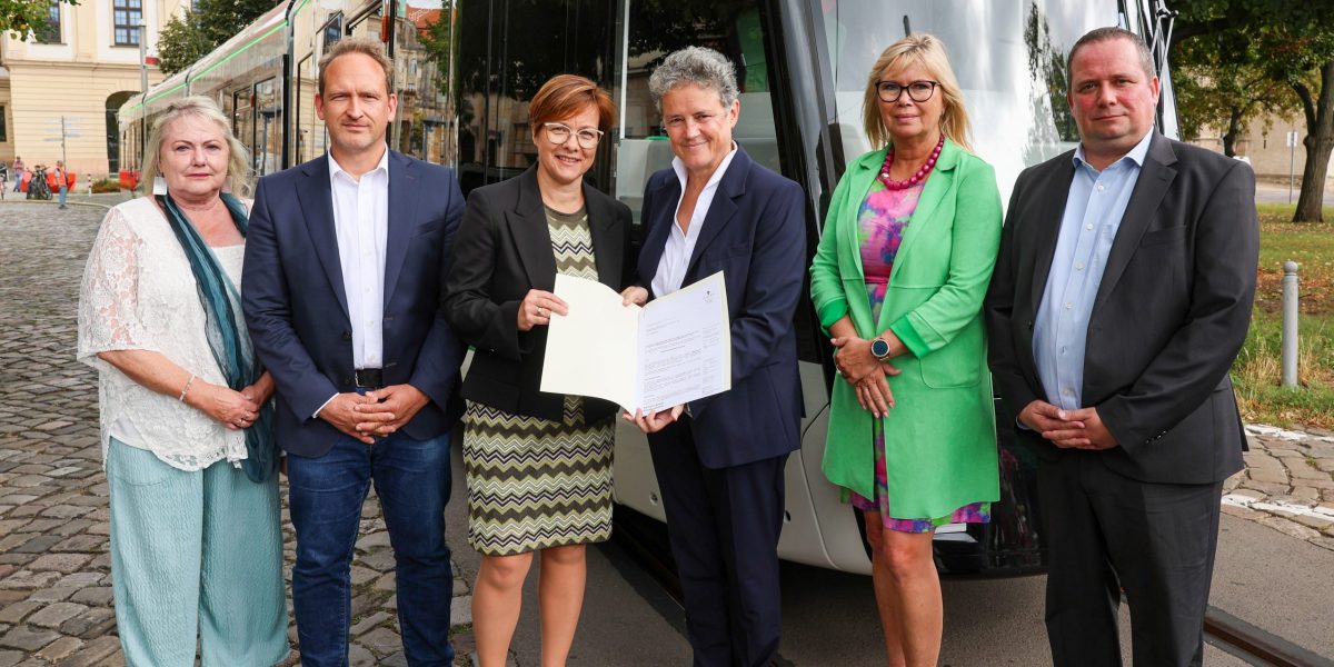 Von links nach rechts: Sprecherin des Fahrgastbeirates Renate Wachsmann, Stadtrat Falko Grube, MVB Geschäftsführerin Birgit Münster-Rendel, Verkehrsministerin Dr. Lydia Hüskens, Oberbürgermeisterin Simone Borris und Alstom Projektleiter André Daniel stehen vor der neuen Straßenbahn. Ministerin Hüskens überreicht Frau Münster-Rendel die Zulassung der neuen Straßenbahn.